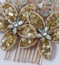 Gold floral hair comb with sequins and beads on a light background